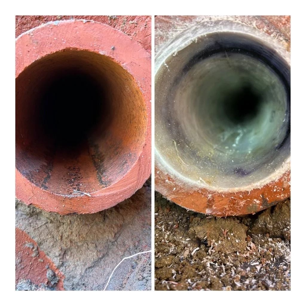 Side-by-side close-up of two dirty drainage pipes, one terracotta and one gray, both with dark interiors.