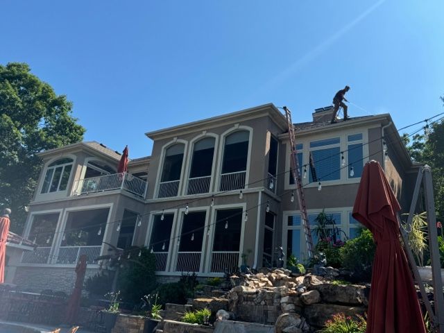 A ladder is sitting on the side of a white house.