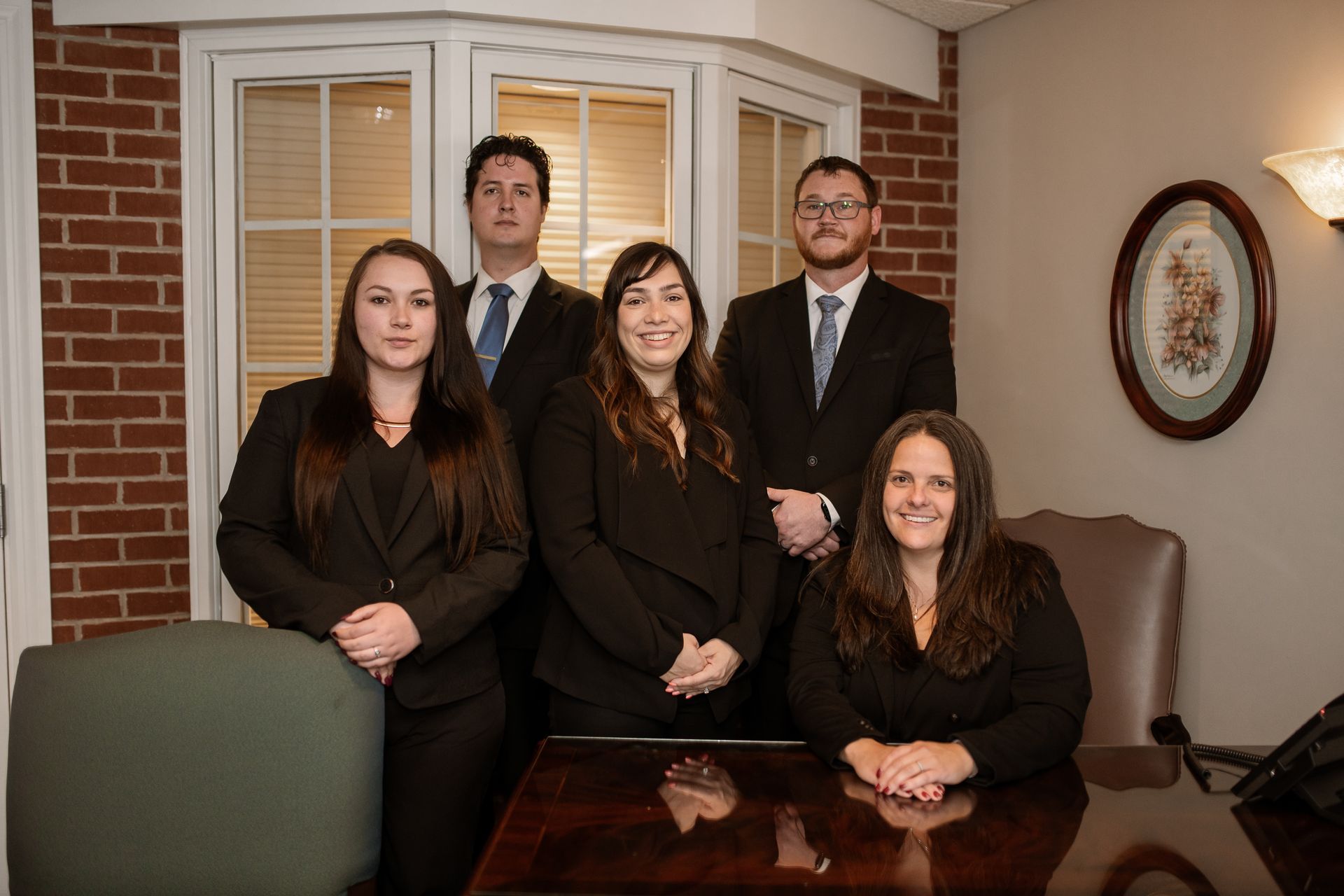 A group of people in suits and ties are posing for a picture.