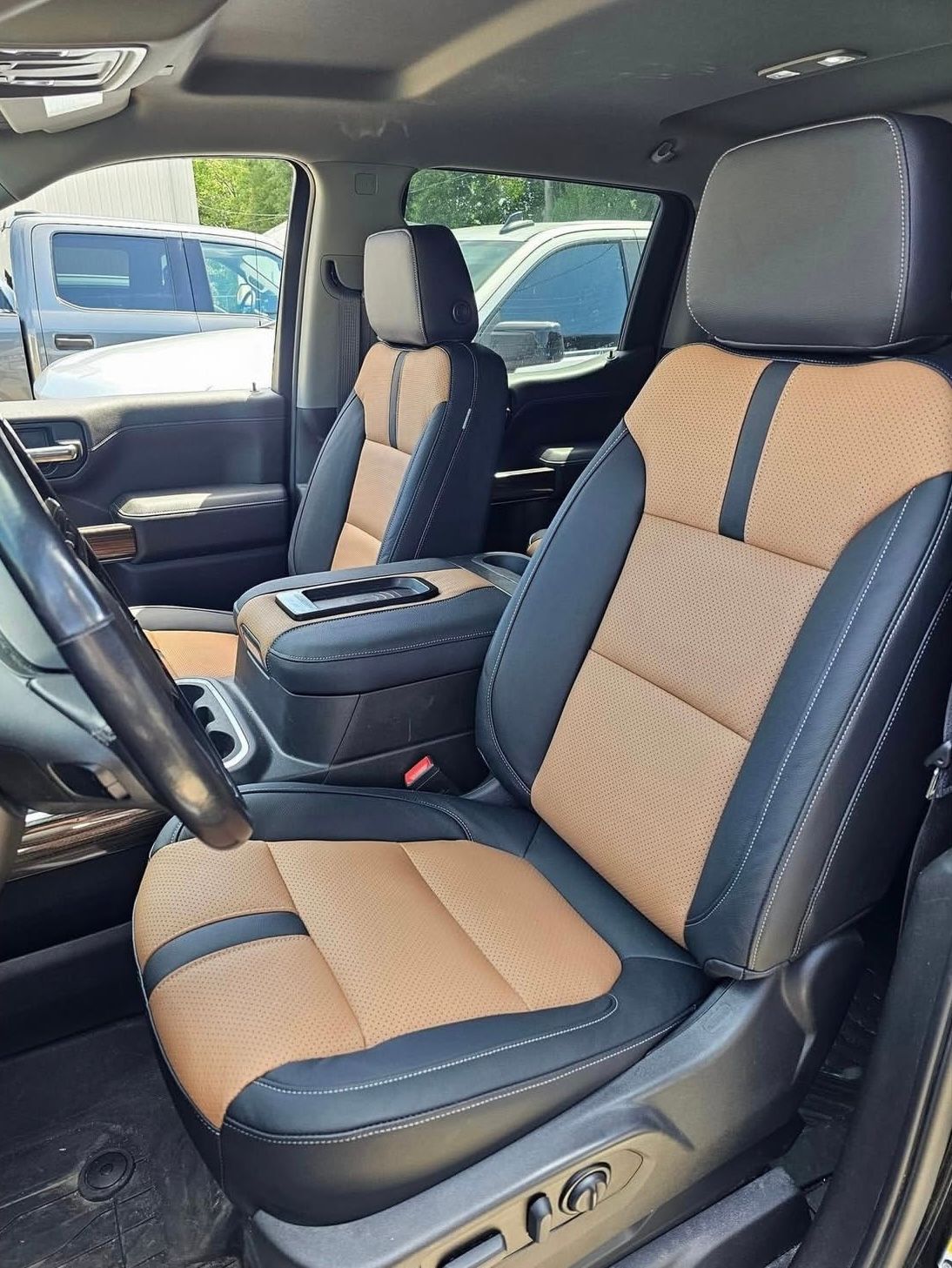 The front seats of a truck are black and tan.