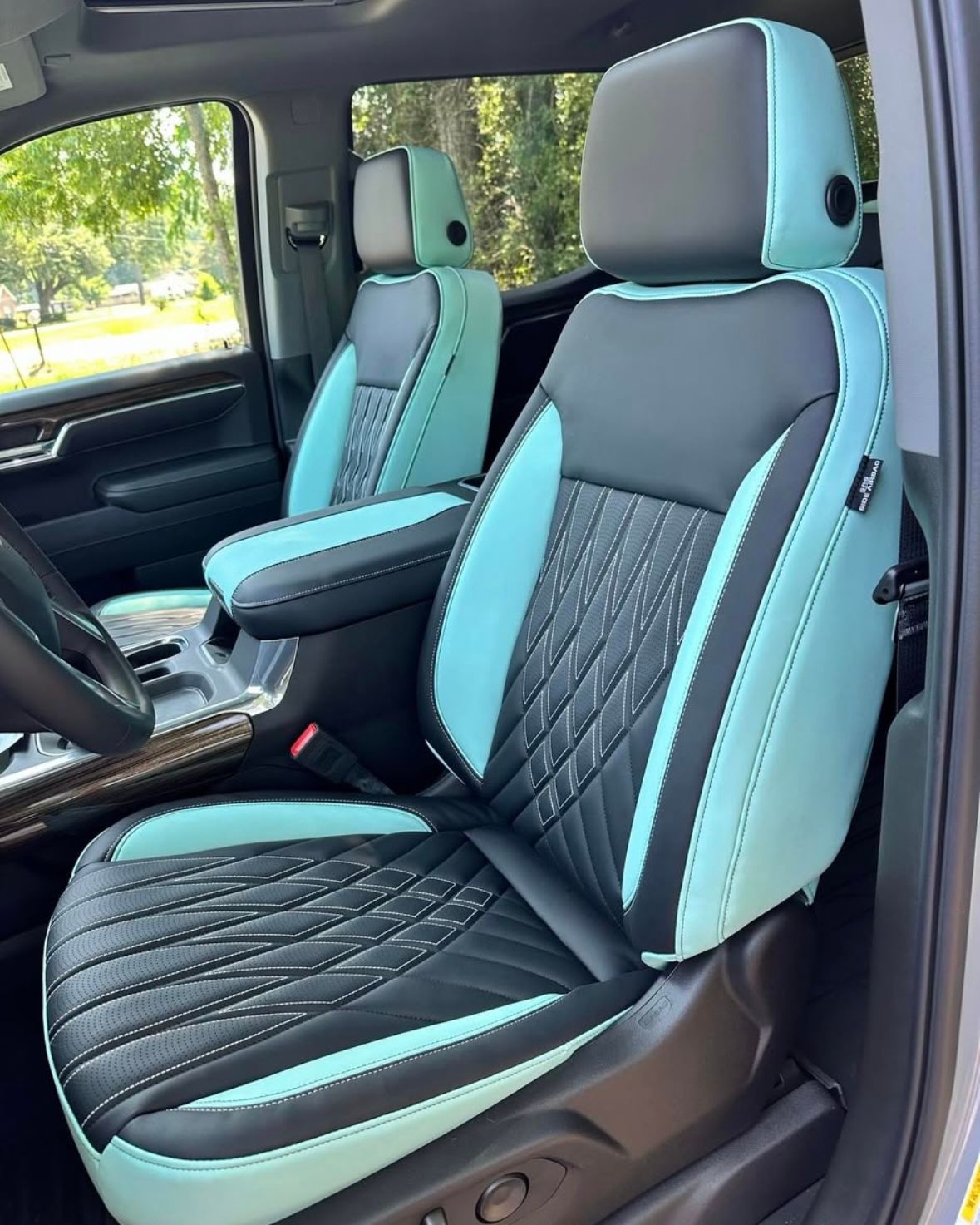 The interior of a car with black and teal seats.