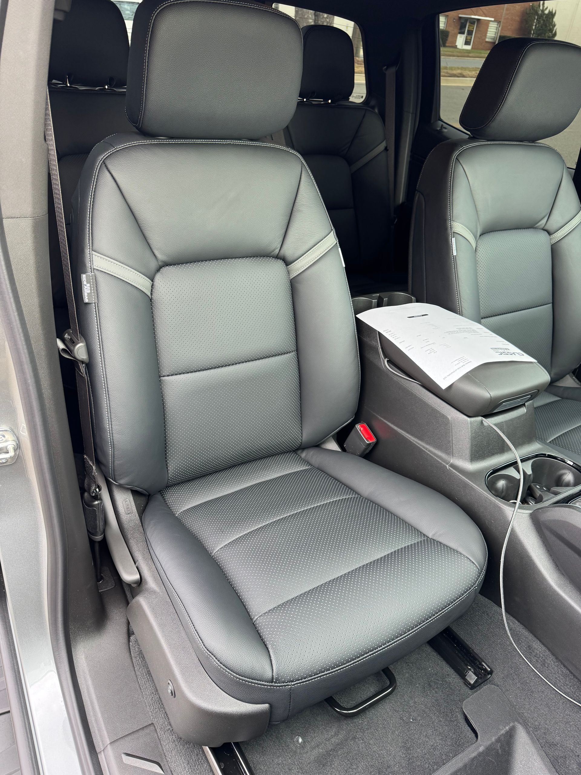 A black leather seat in the back of a car.