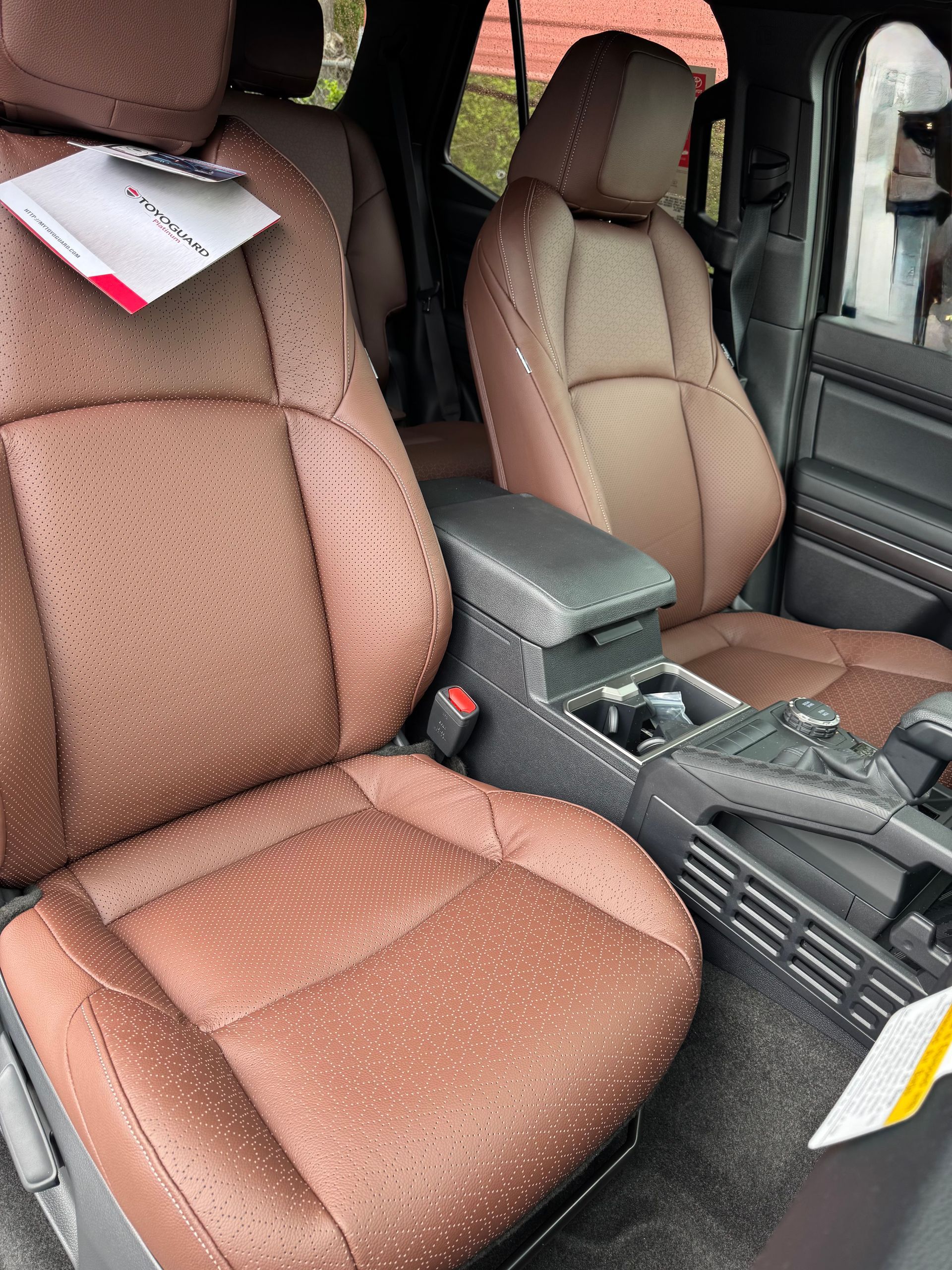 A close up of the interior of a car with brown leather seats.
