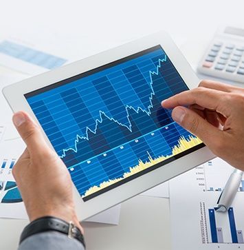 A person is holding a tablet with a graph on it.