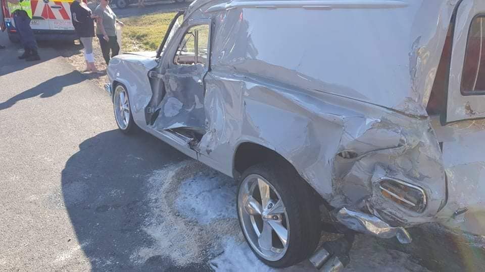 Damaged white pickup truck after an accident on a road. People and an ambulance are in the background — Fulgi’s South Coast Automotive and Dismantling in Nowra, NSW
