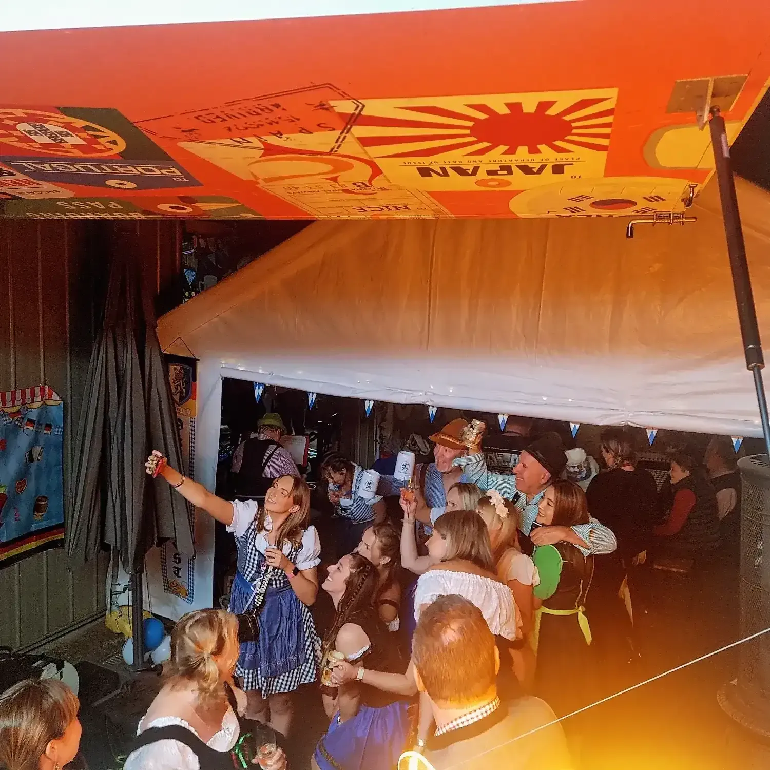 A group of people are gathered under a tent with a sign that says Cest Chick Food truck catering