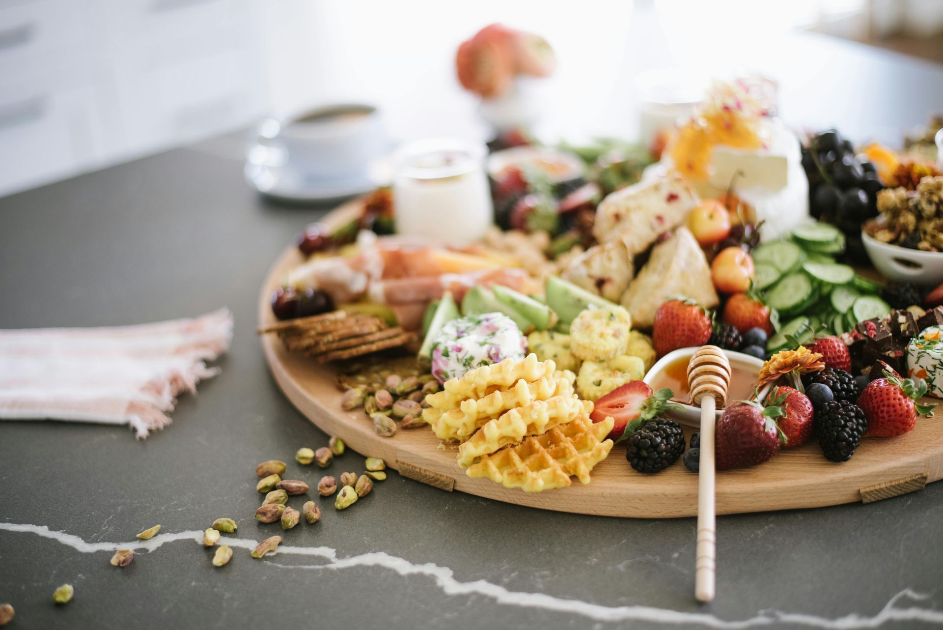A wooden cutting board filled with fruits and vegetables on a table for a Christmas Party Catering.
