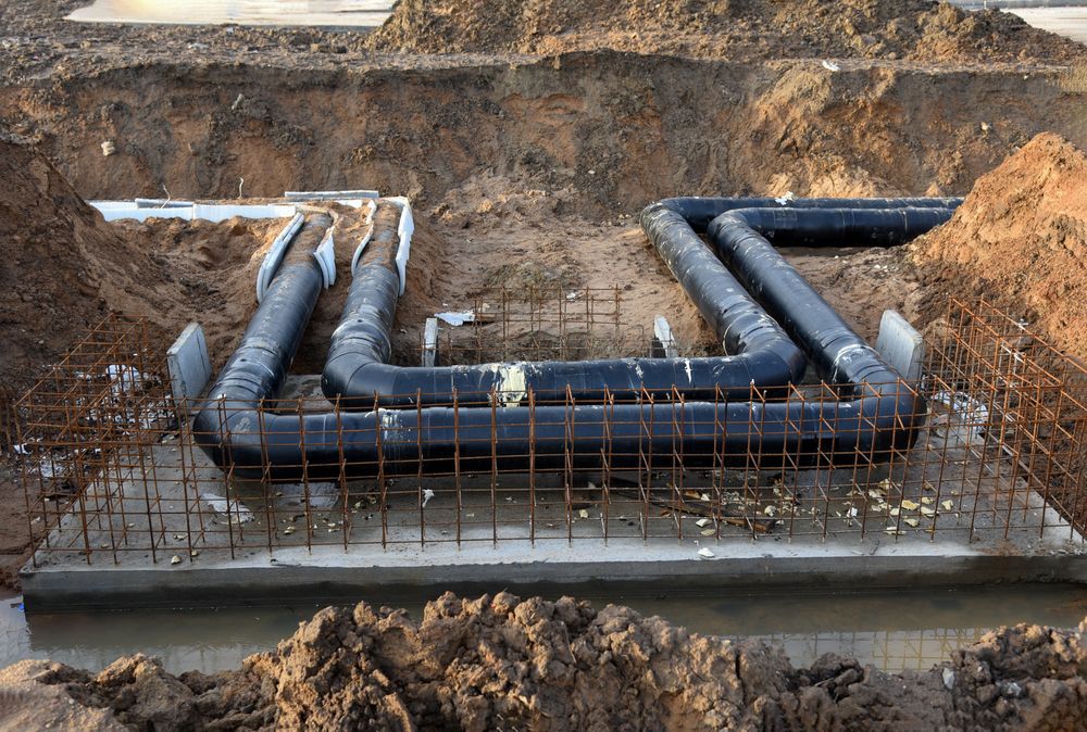 A Bunch Of Pipes Are Laying In The Dirt  — Flash Concreting Pty Ltd In Nindaroo, QLD