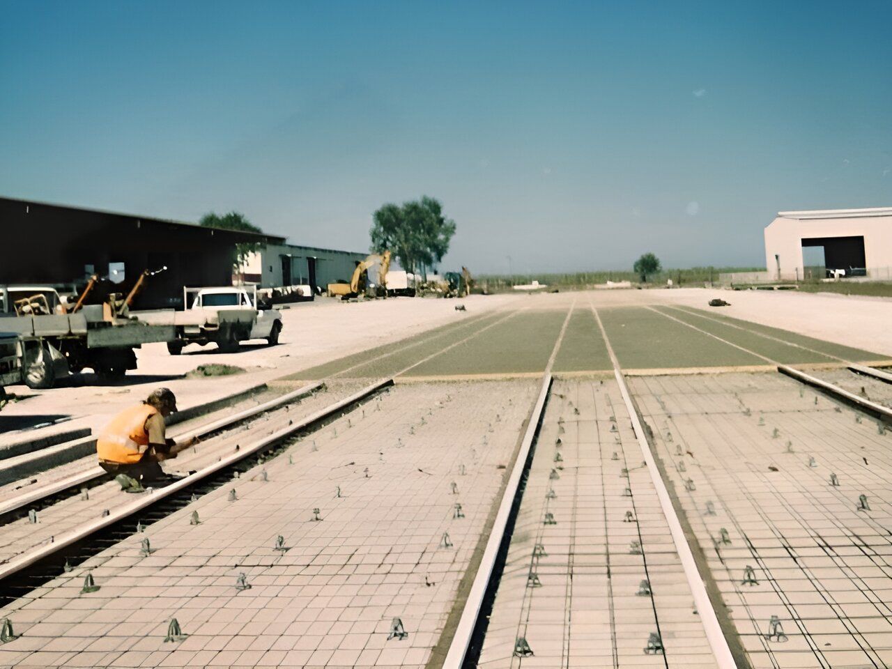 A Man In An Orange Vest Is Working On A Concrete Surface — Flash Concreting Pty Ltd In Nindaroo, QLD