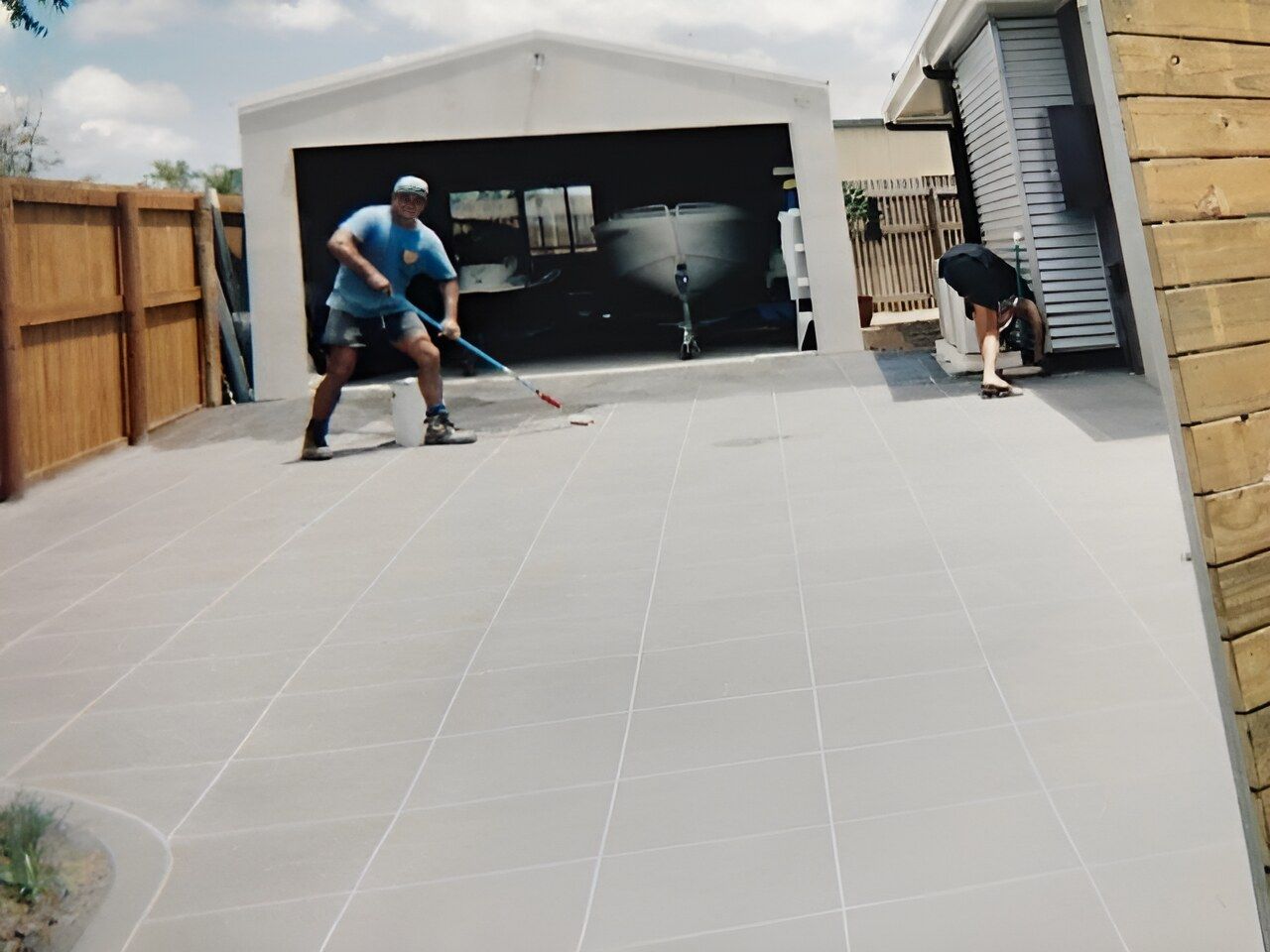 A Man Is Standing In Front Of A Garage — Flash Concreting Pty Ltd In Proserpine, QLD