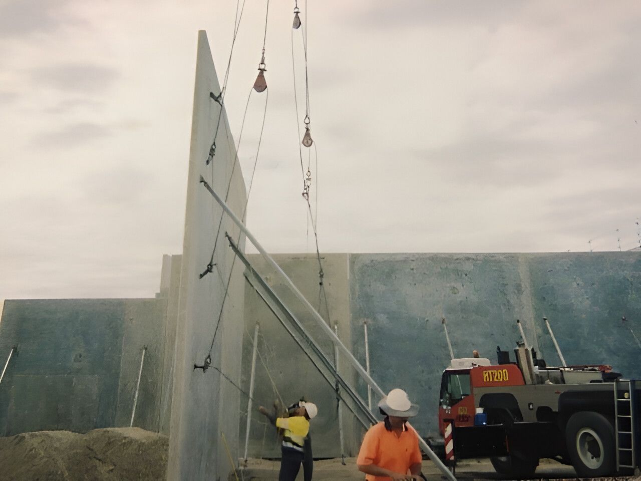 A Man Is Standing In Front Of A Crane That Says Vtd On It — Flash Concreting Pty Ltd In Proserpine, QLD