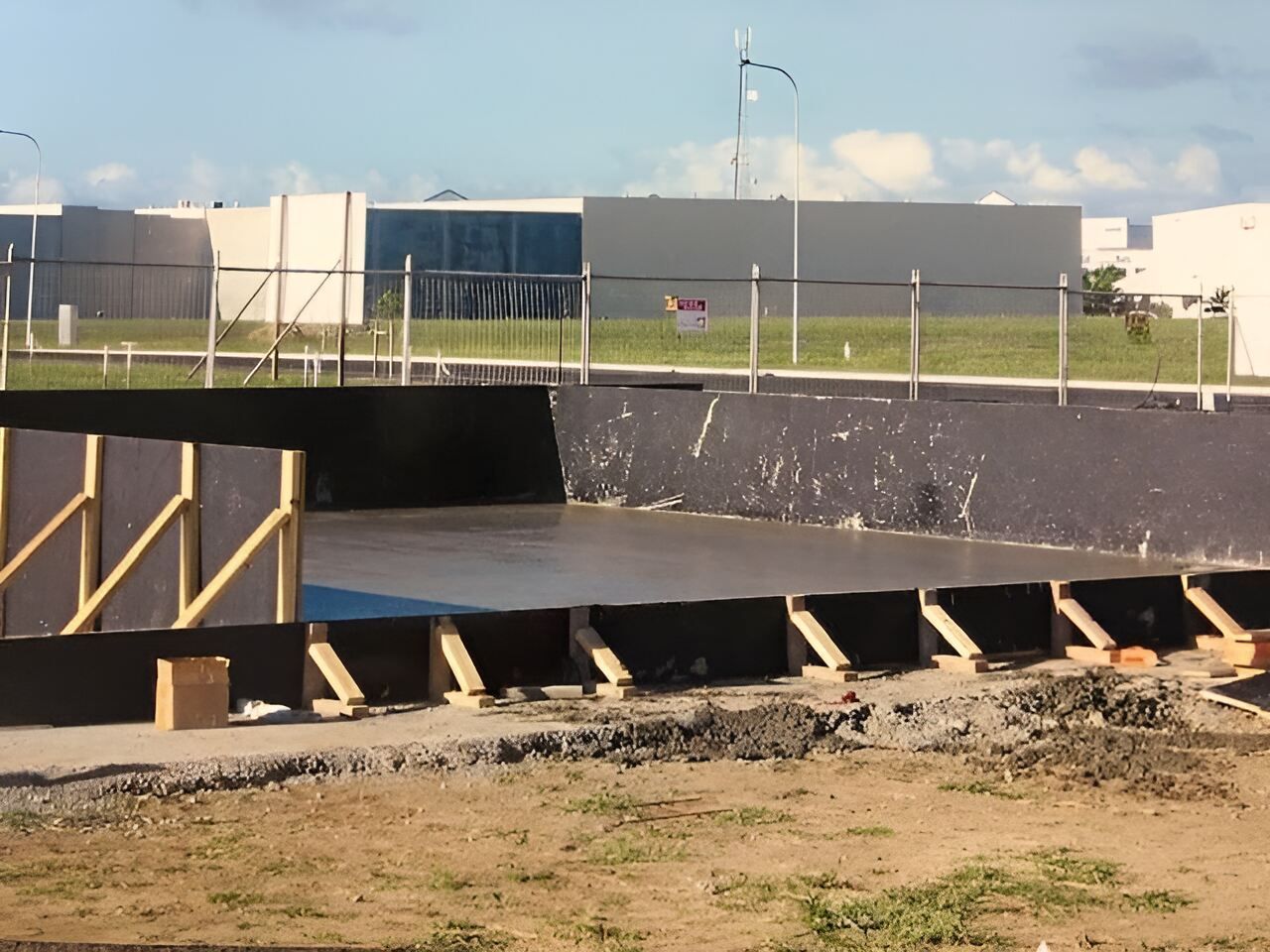 A Construction Site With A Large Building In The Background — Flash Concreting Pty Ltd In Nindaroo, QLD