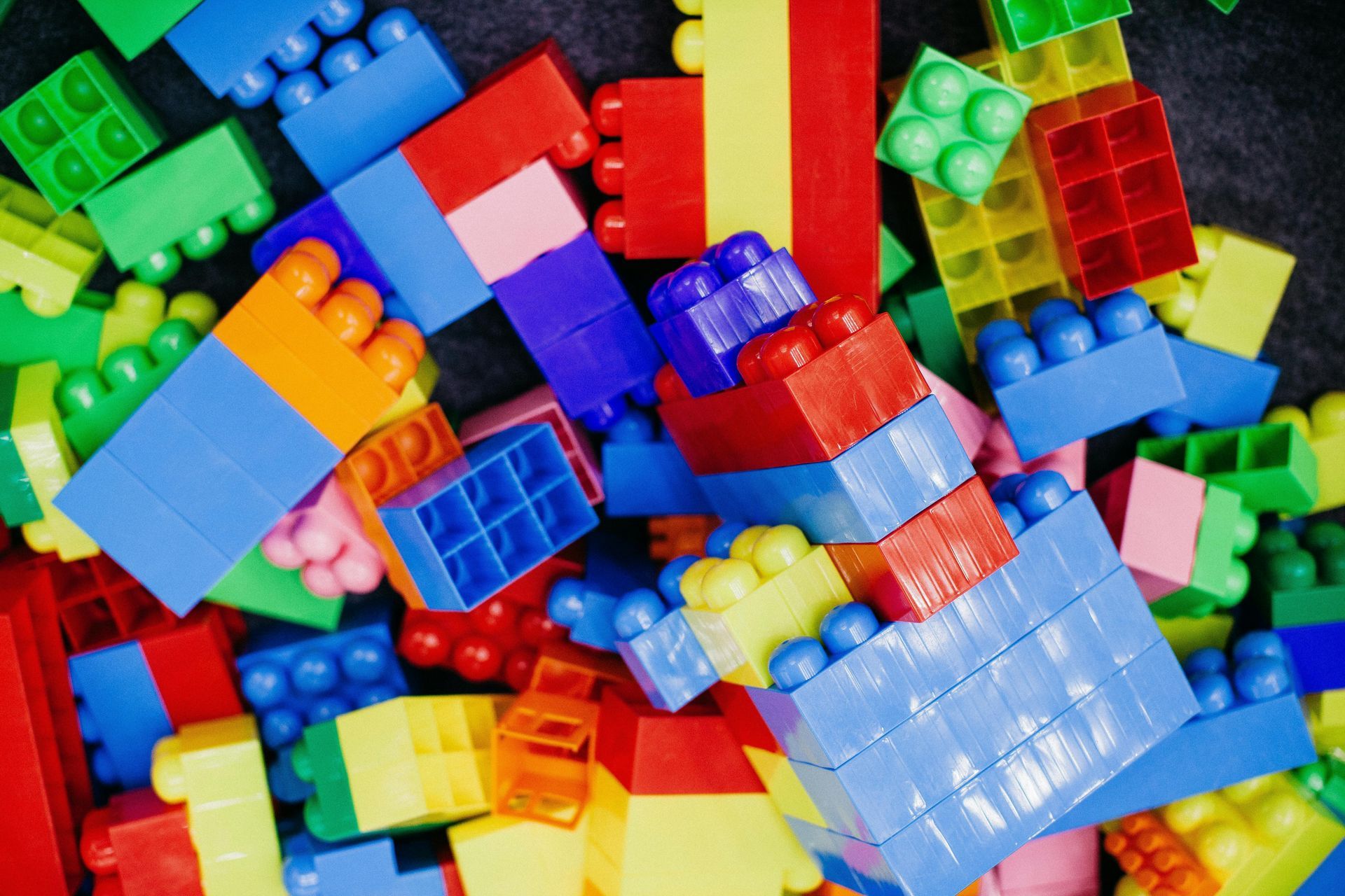 Colorful building blocks in a jumbled pile, including red, blue, green, and yellow.