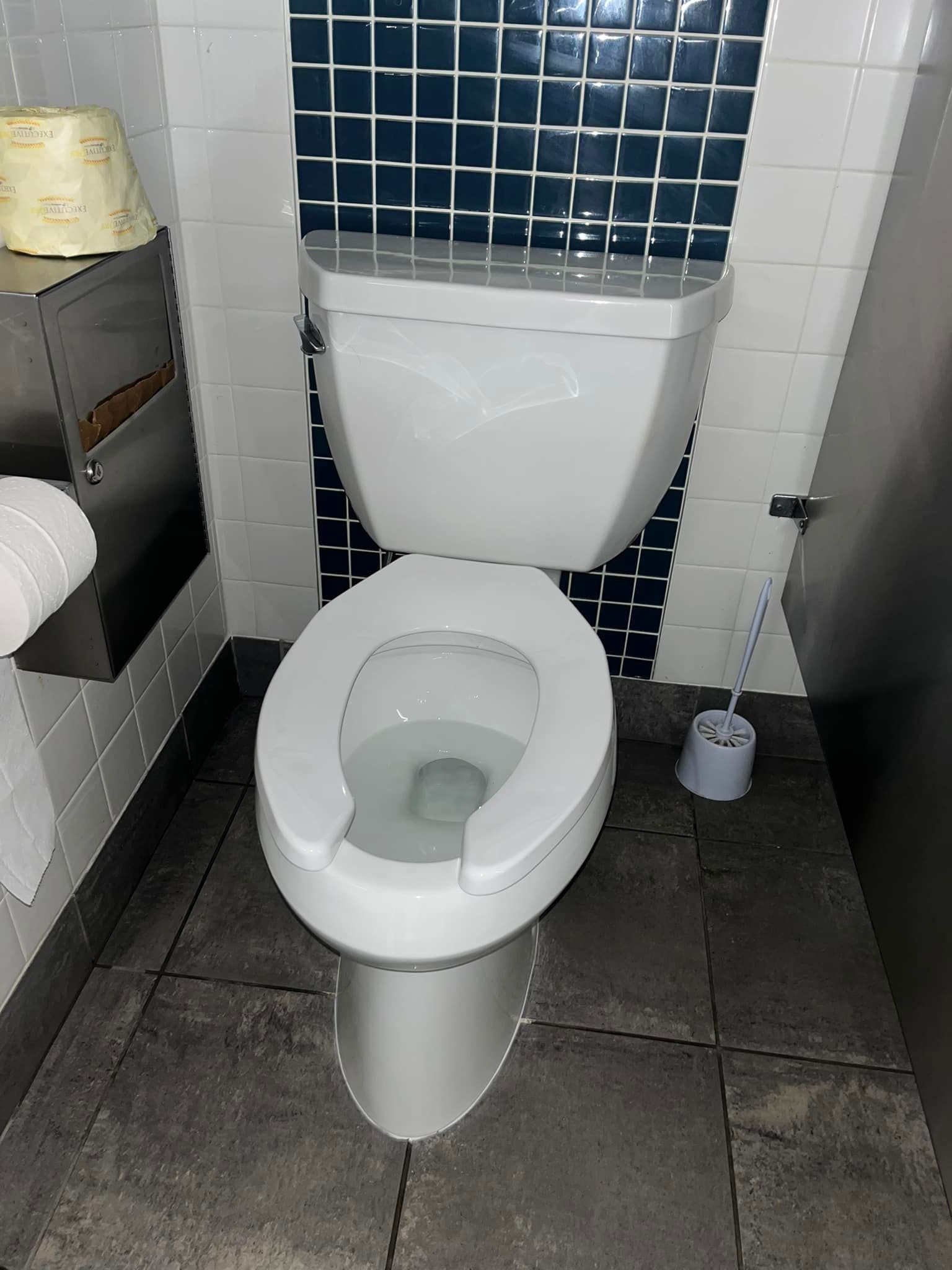 Aqua Plumbing Pros | A toilet in a bathroom with blue and white tiles