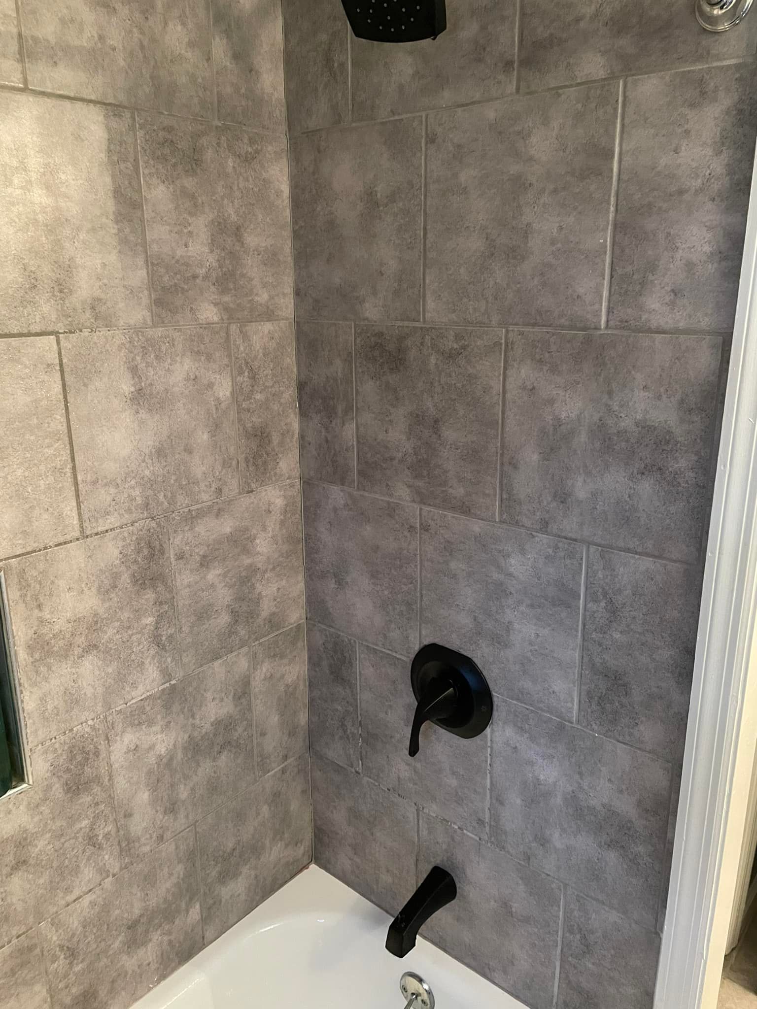 Aqua Plumbing Pros | A bathroom with a bathtub and a shower with black faucets.