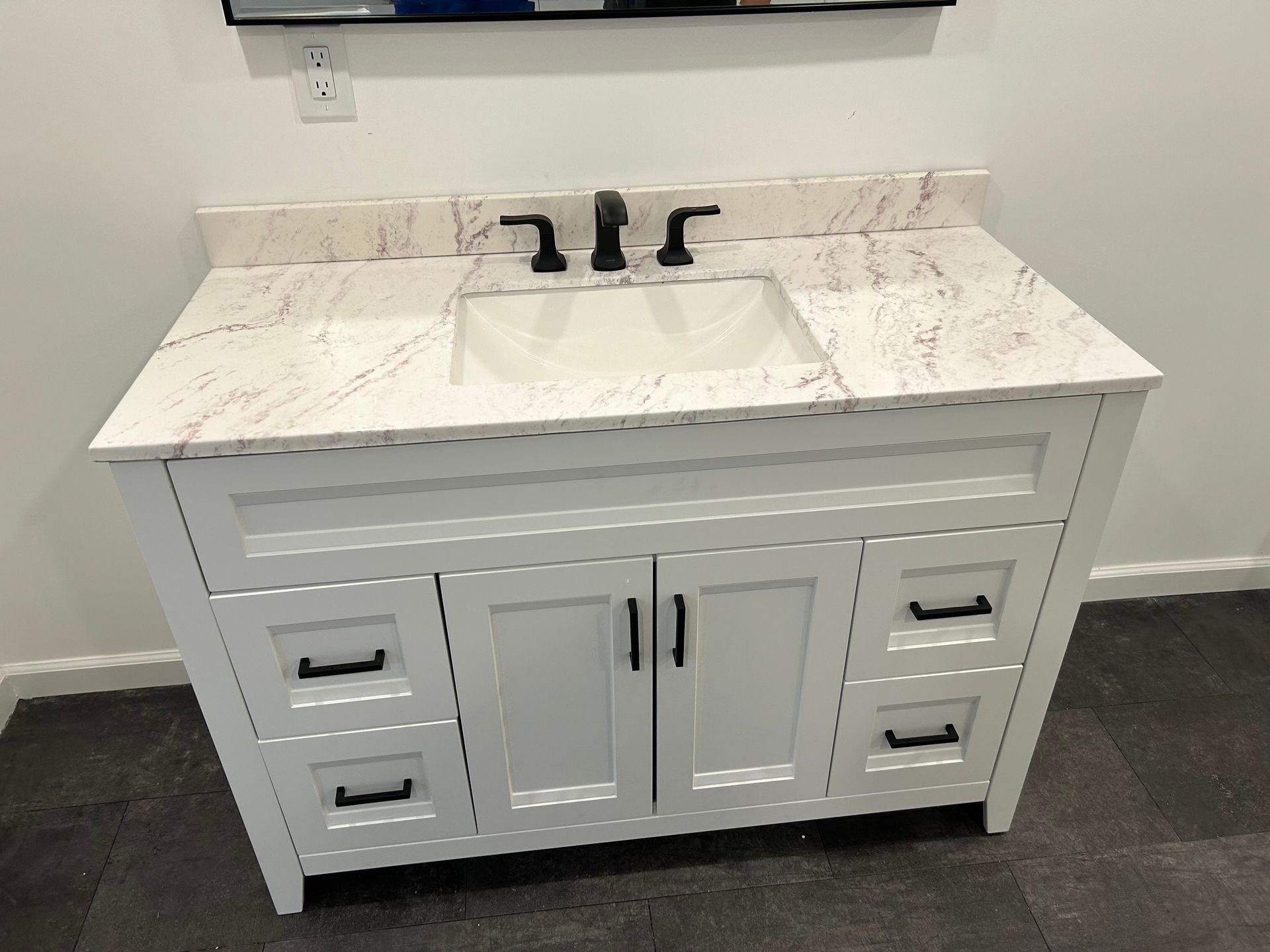 Aqua Plumbing Pros | A bathroom vanity with a sink and a mirror.