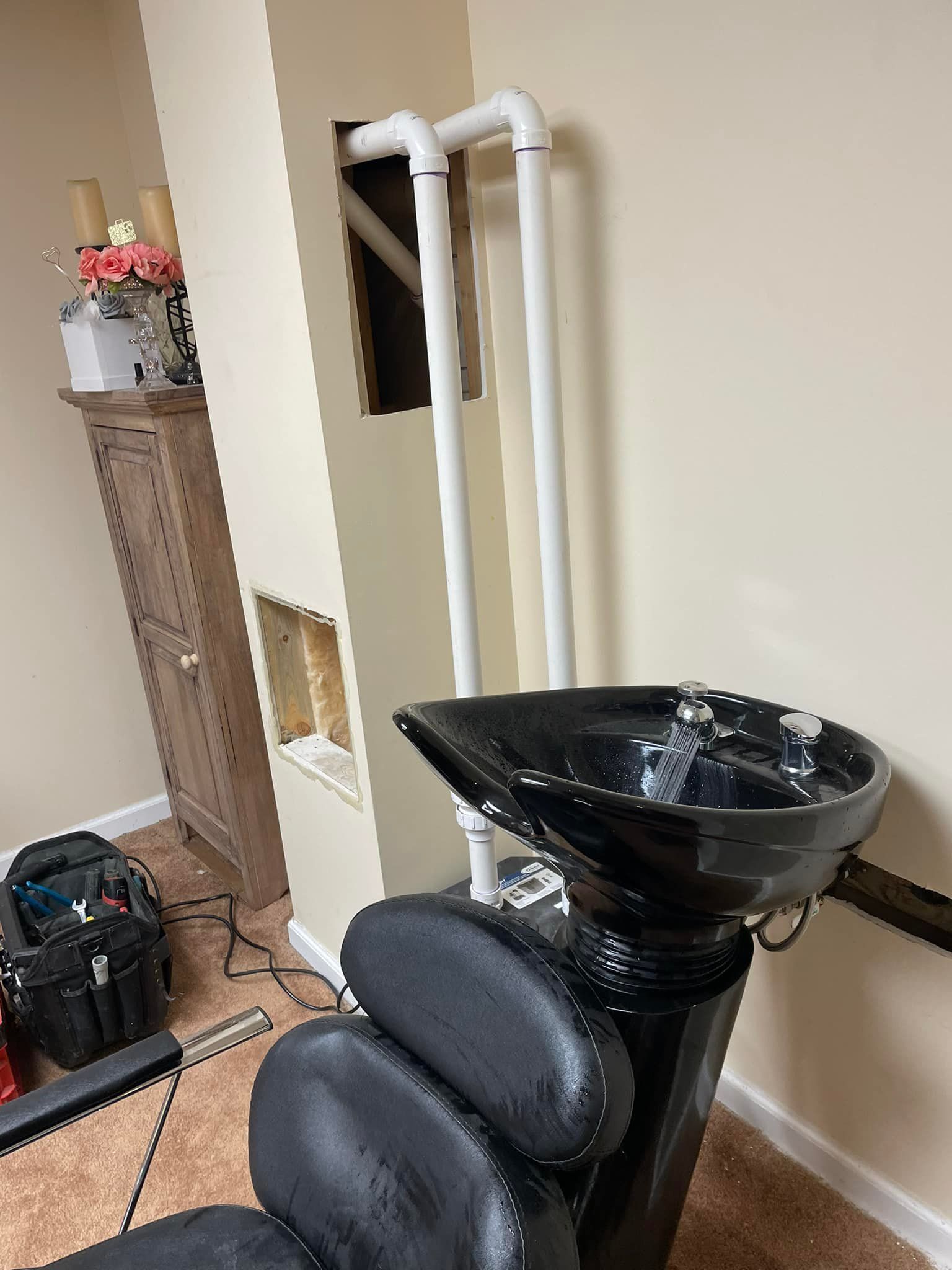 Aqua Plumbing Pros | A black hair salon chair with a sink attached to it.