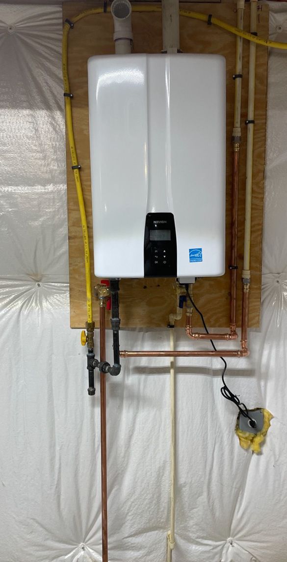 Aqua Plumbing Pros | A white water heater is hanging on a wall next to copper pipes.