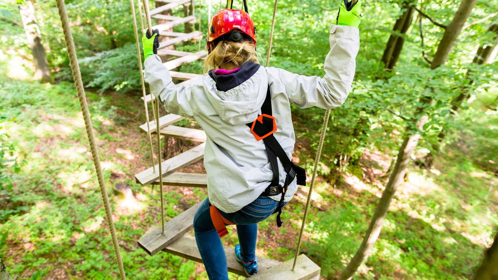 Lady on high ropes course from behind