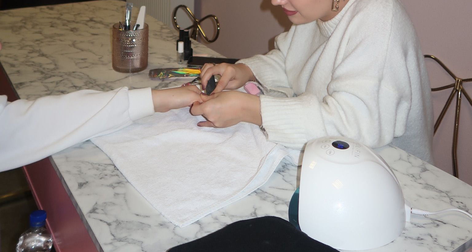 Eine Nahaufnahme einer rosa Pipette, aus der ein Tropfen Flüssigkeit herauskommt.