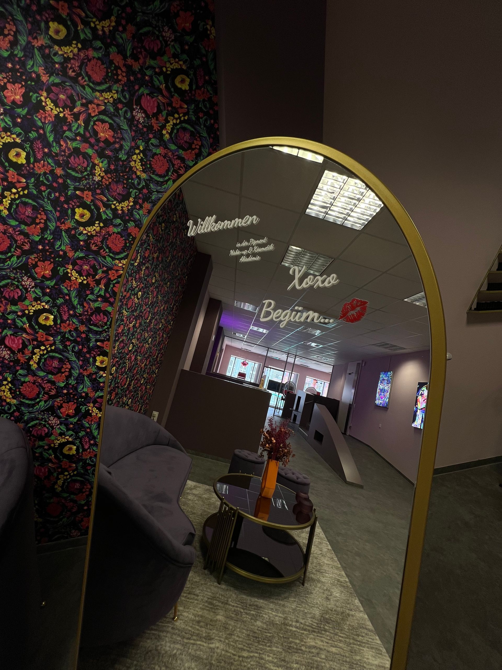 Ein großer Spiegel in einem Zimmer mit einem Sofa und einem Tisch.