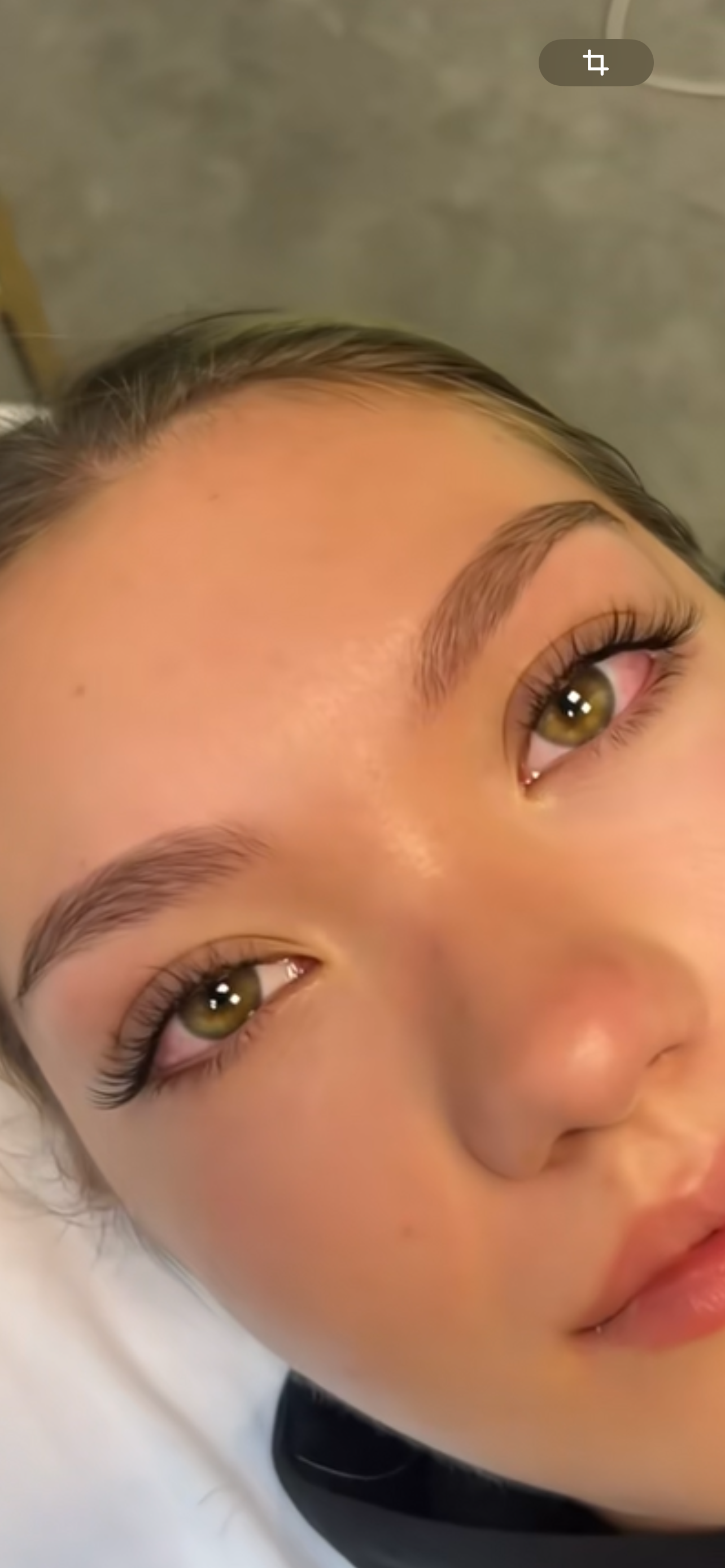 Eine Nahaufnahme des braunen Auges einer Frau mit langen Wimpern.