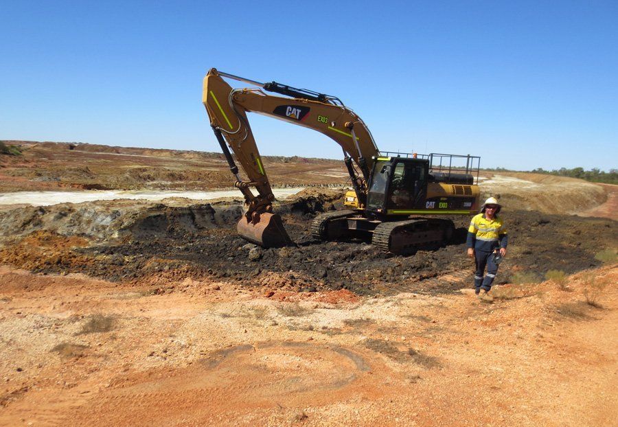 worker beside excavator