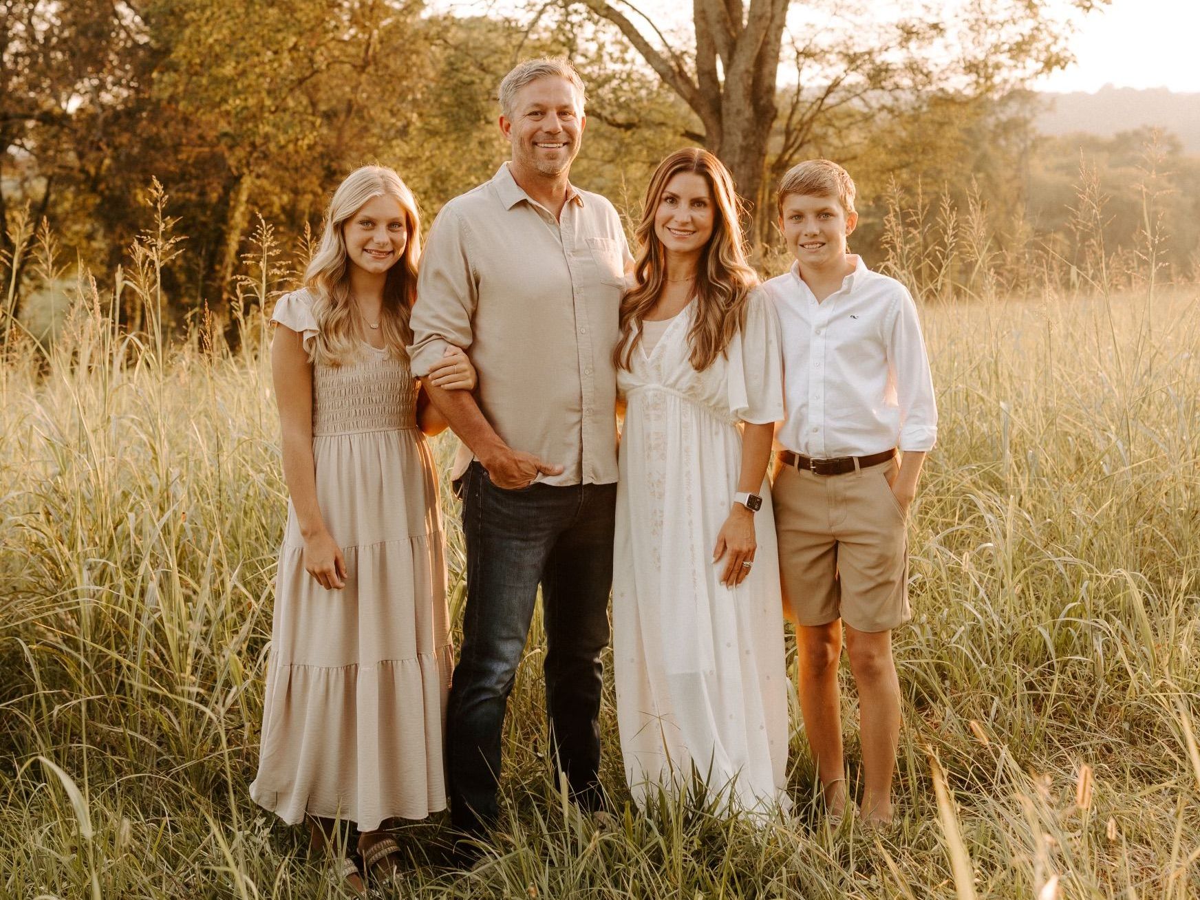 A family is posing for a picture in a field.