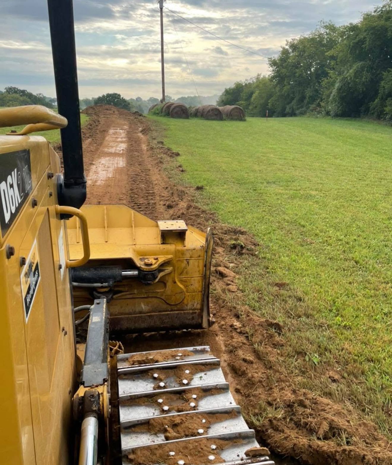 A yellow bulldozer is sitting in a pile of dirt and rocks