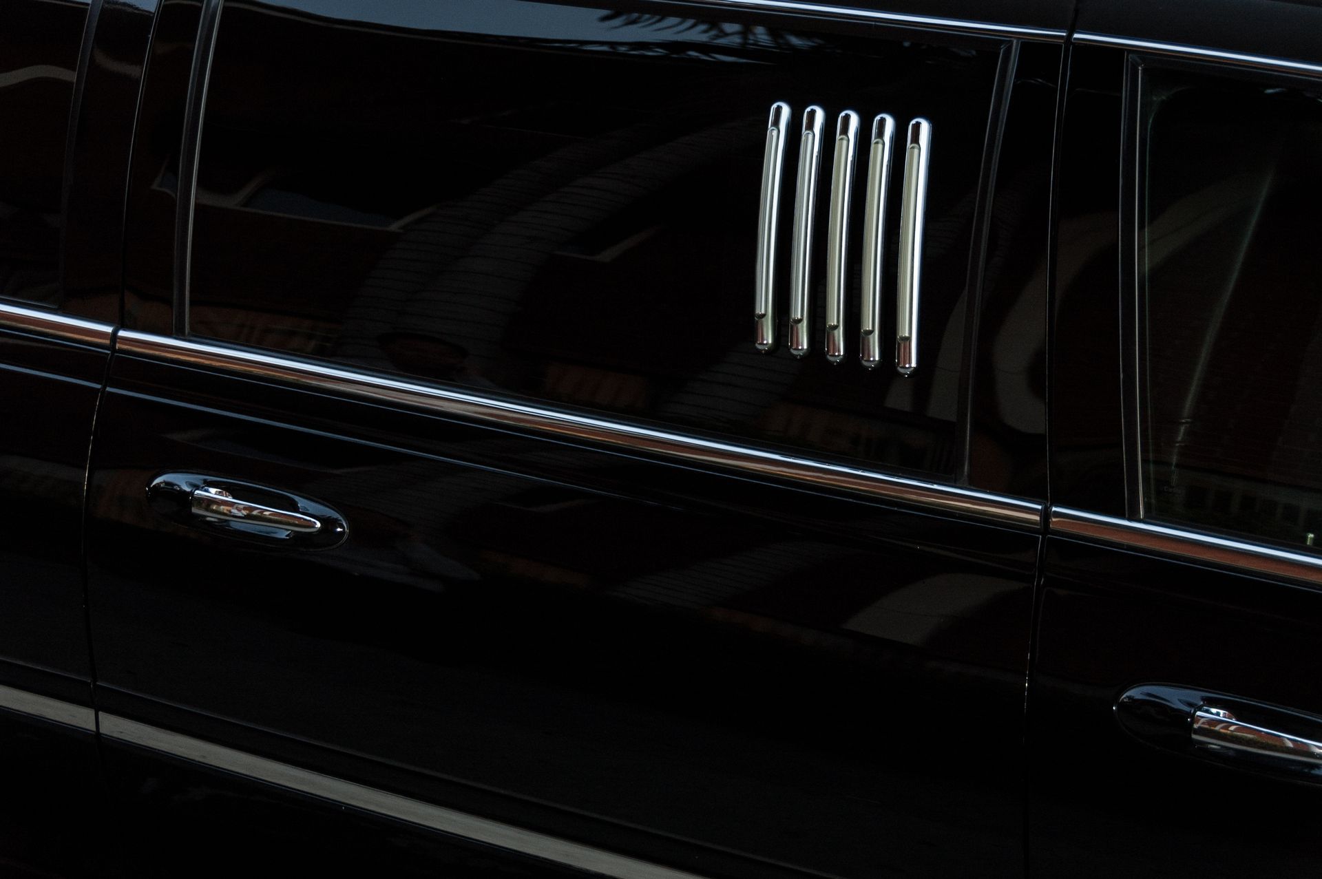 A close up of a black limousine with chrome trim