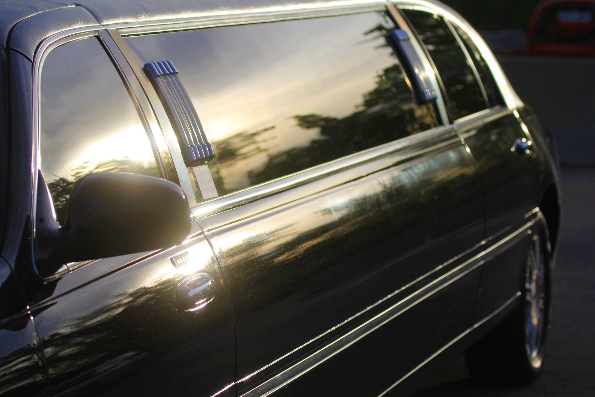 A black limousine is parked on the side of the road