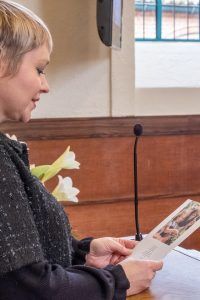 a woman is sitting at a table reading a book .