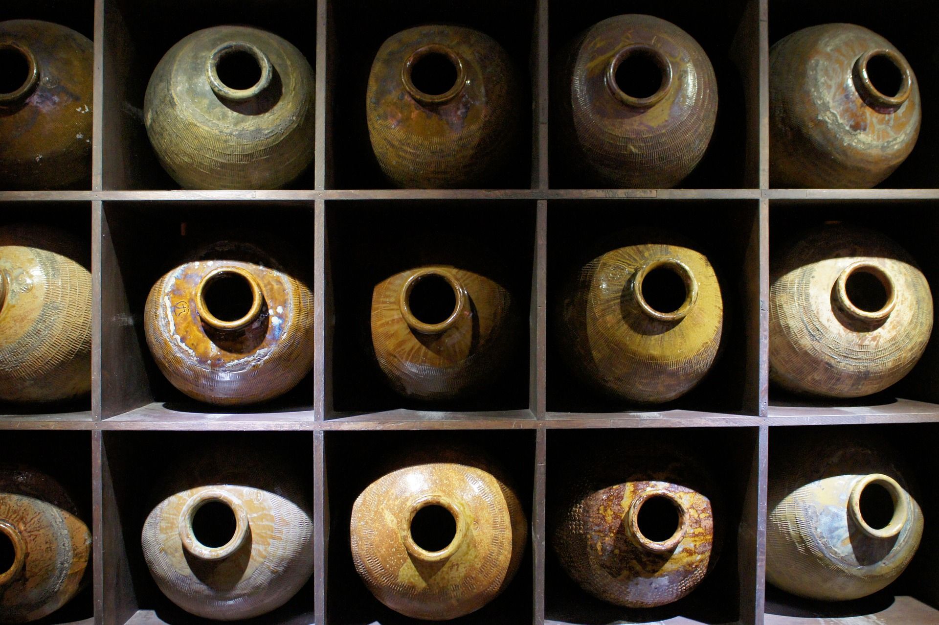 a shelf filled with lots of clay pots with holes in them