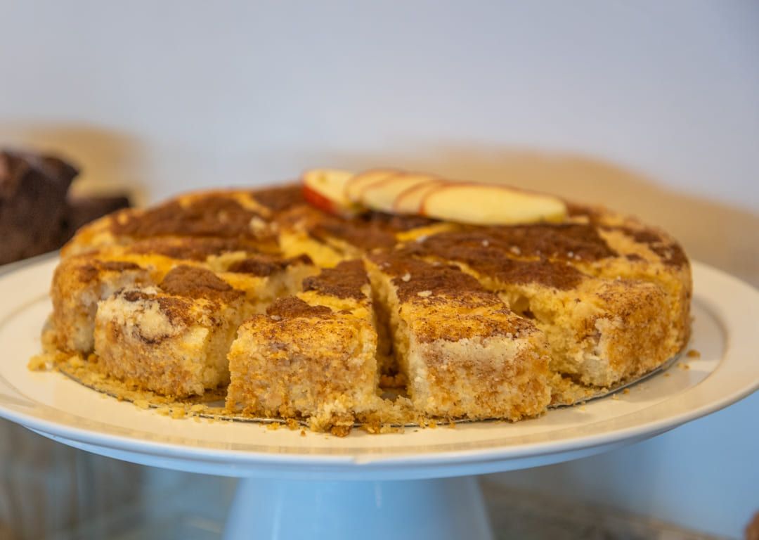 Um bolo com uma fatia retirada dele está em um prato branco.