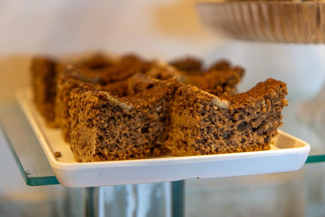 Um prato branco coberto com fatias de bolo sobre uma mesa de vidro.