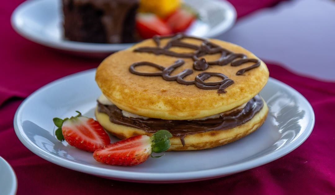 Um donut com chocolate e morangos em um prato branco