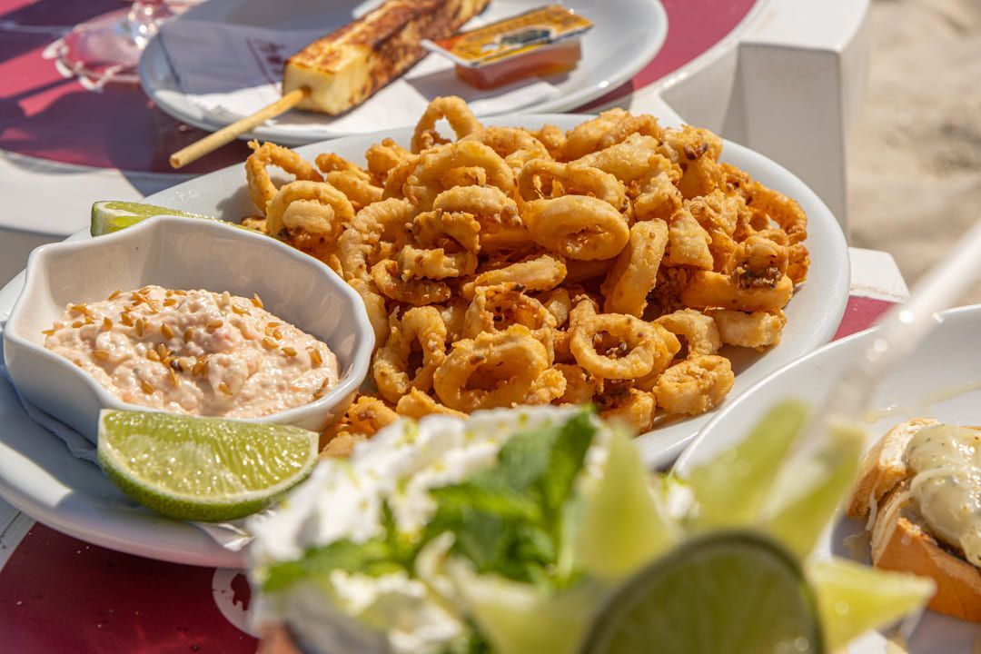 Uma mesa coberta com pratos de comida e uma bebida.