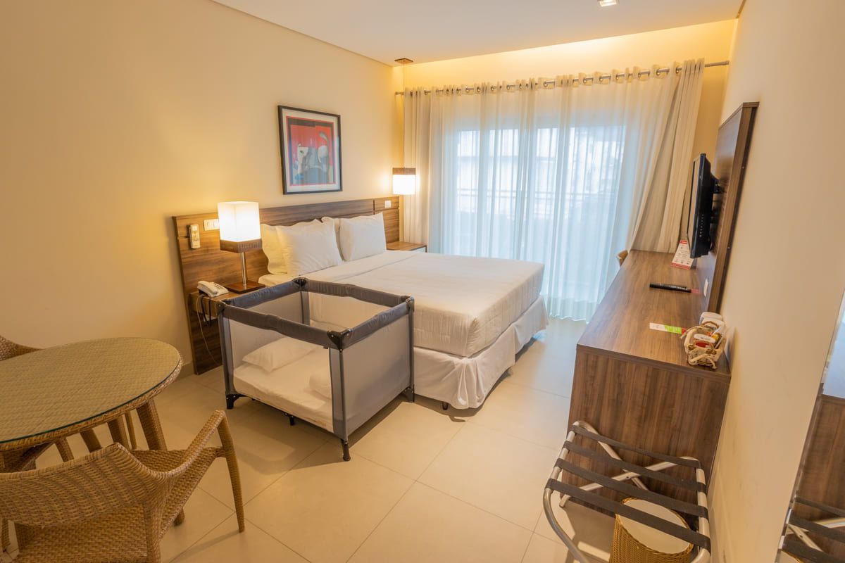 Um quarto de hotel com uma cama grande e um berço.