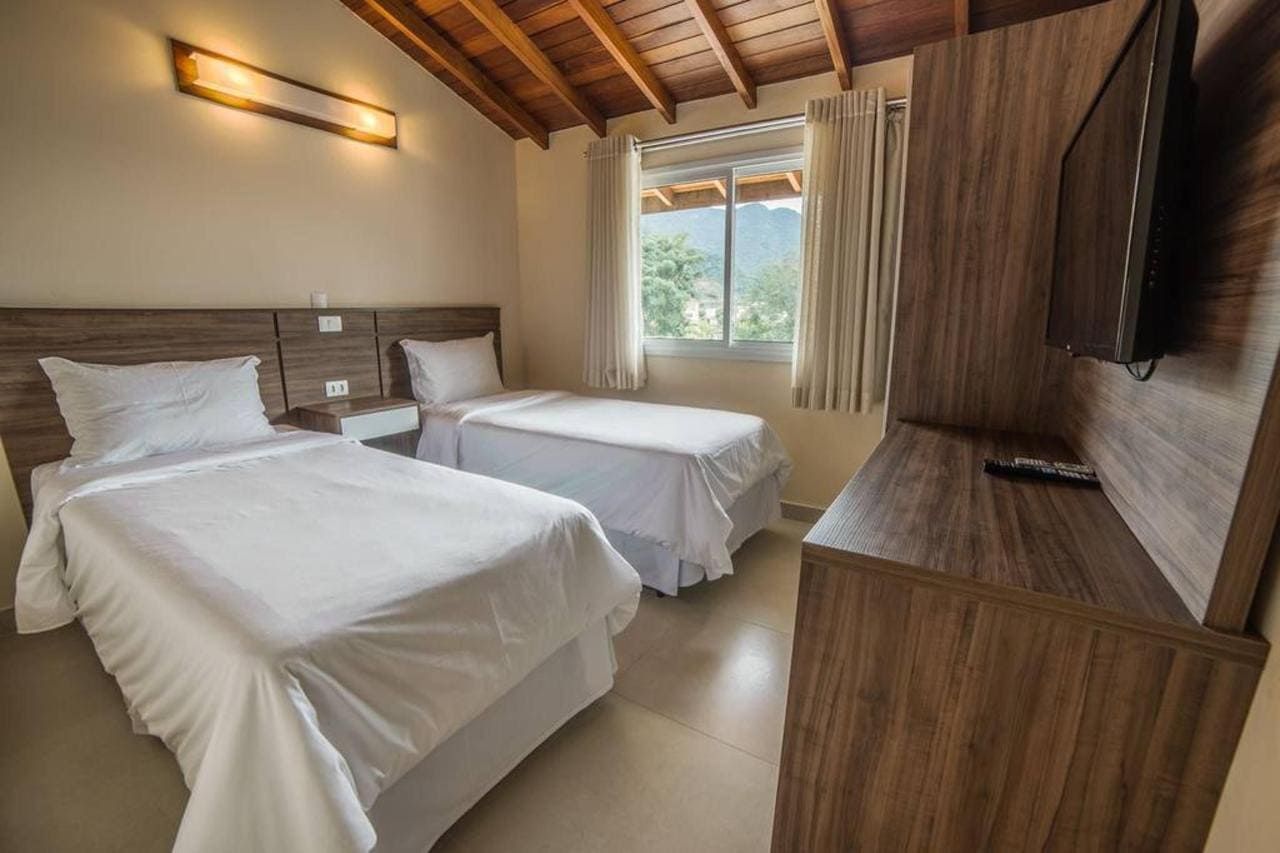 Um quarto de hotel com duas camas e uma TV de tela plana.