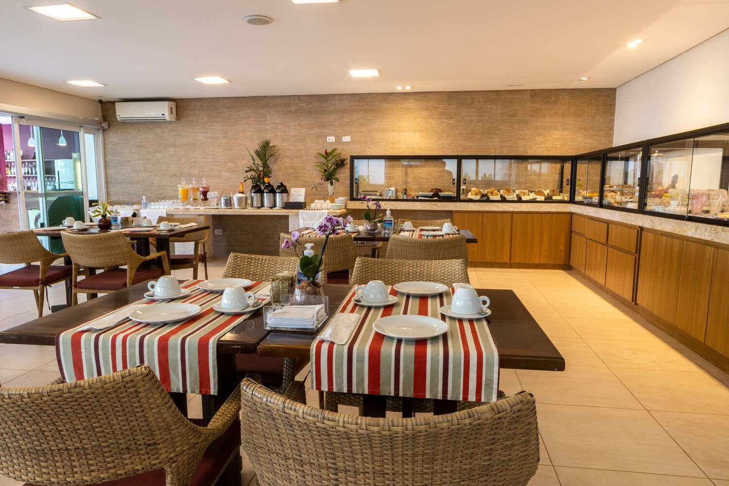 Uma sala de jantar com mesas e cadeiras e um bufê.