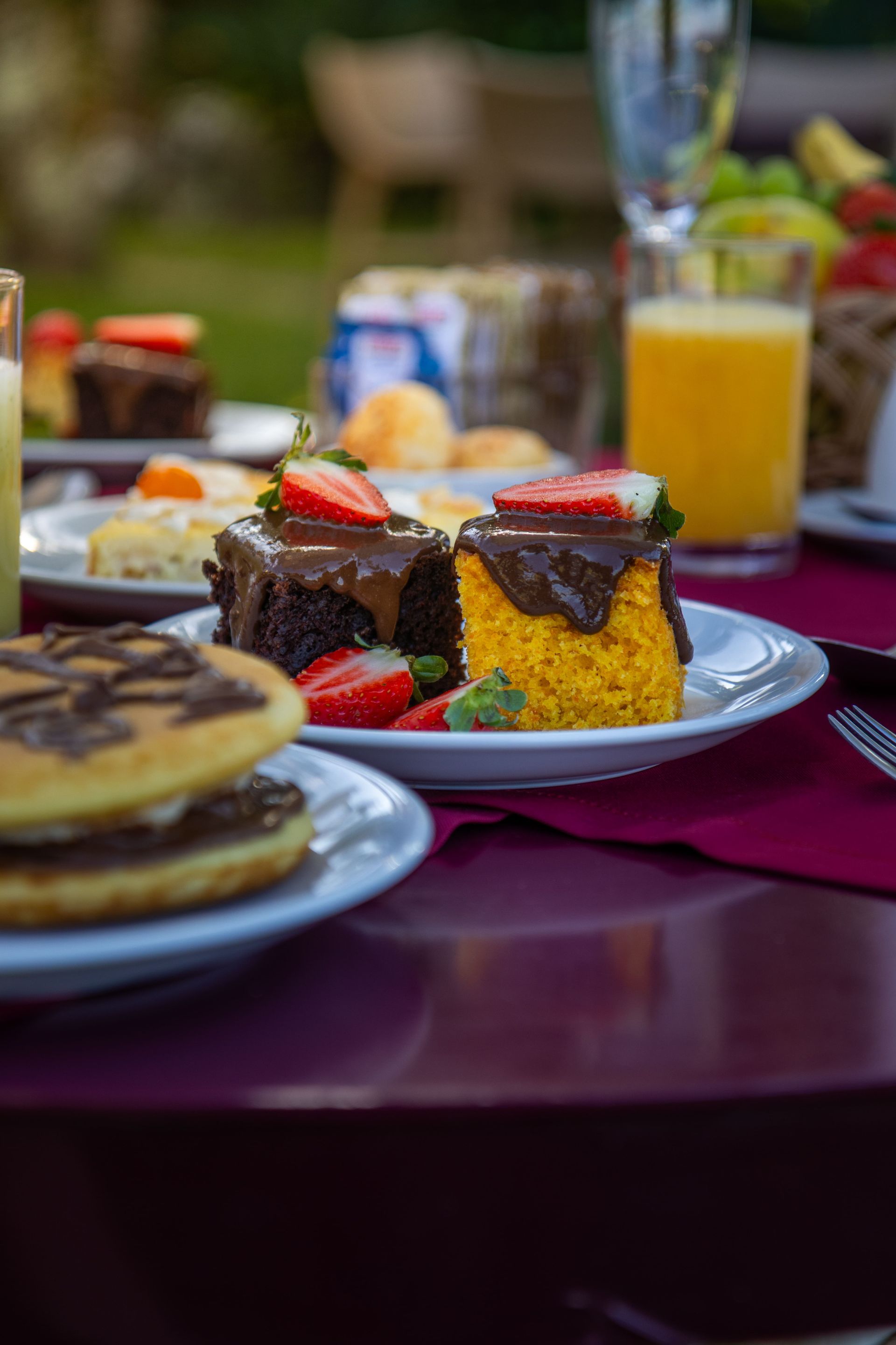 Uma mesa coberta com pratos de comida, incluindo um bolo e panquecas.