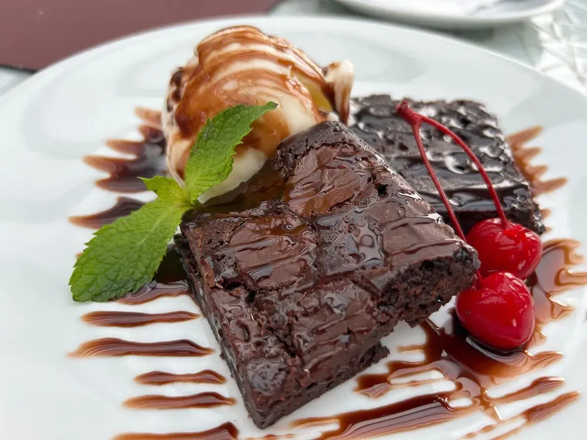 Um brownie com sorvete e uma cereja no topo