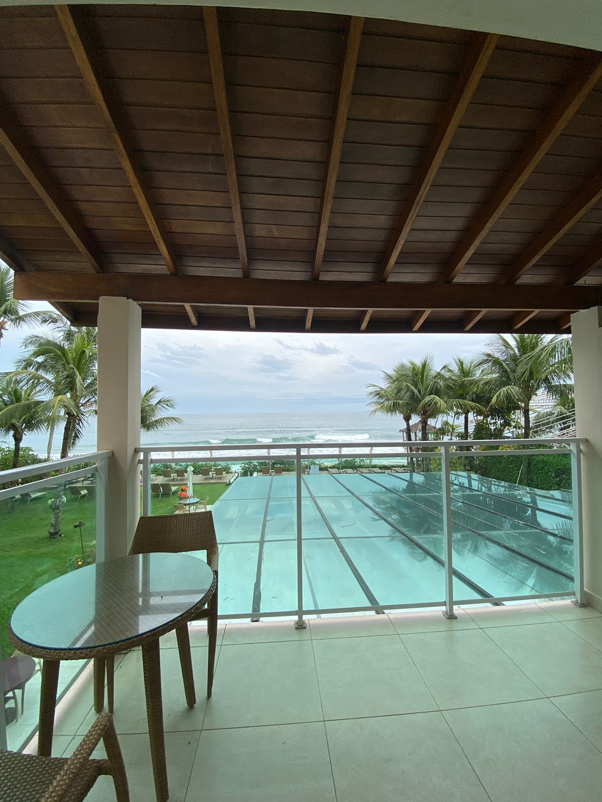 Uma varanda com mesa e cadeiras com vista para o oceano