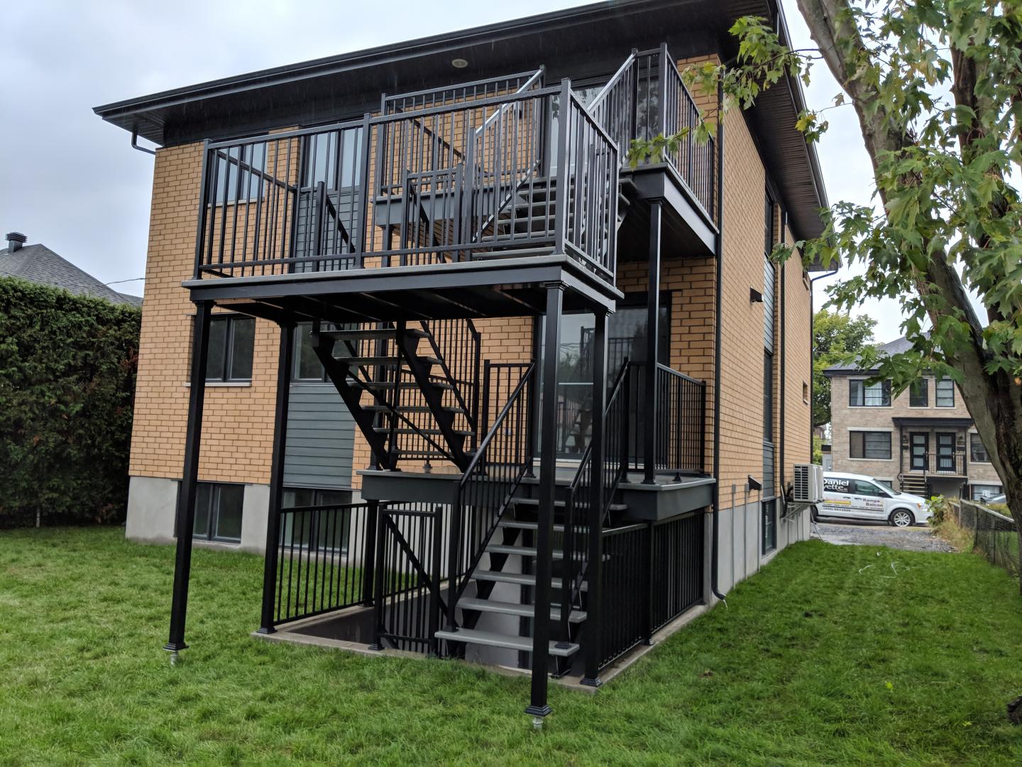 Une maison avec un balcon et des escaliers sur le côté.