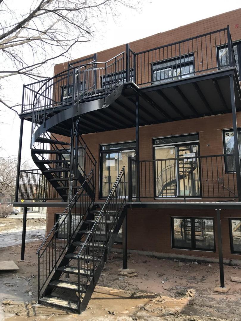 Une maison avec un balcon et des escaliers sur le côté.