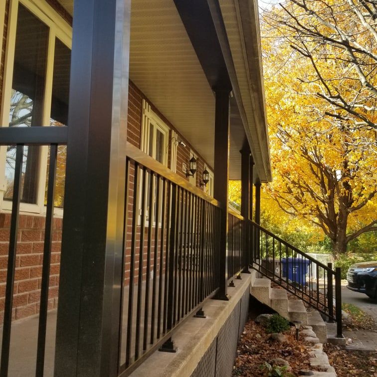 Une maison en brique avec une balustrade et des escaliers noirs