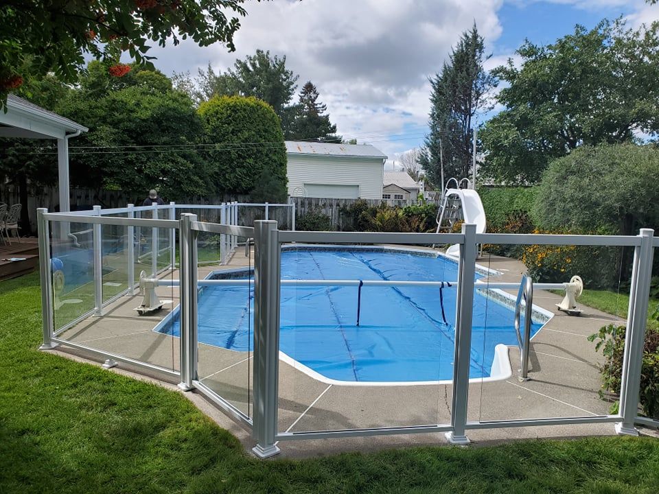 Une piscine avec une clôture autour et un plongeoir.