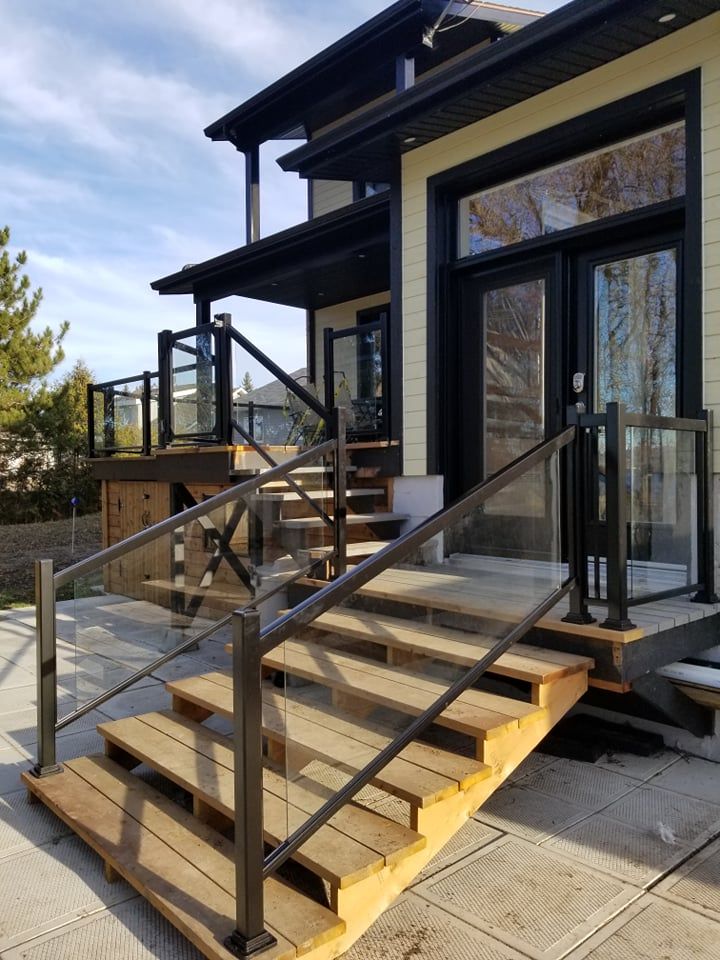 Une maison avec un escalier en bois et une balustrade en verre.