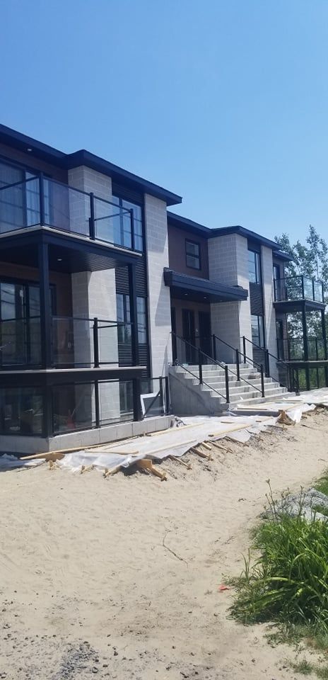 Une rangée de maisons est en construction dans une zone sablonneuse.