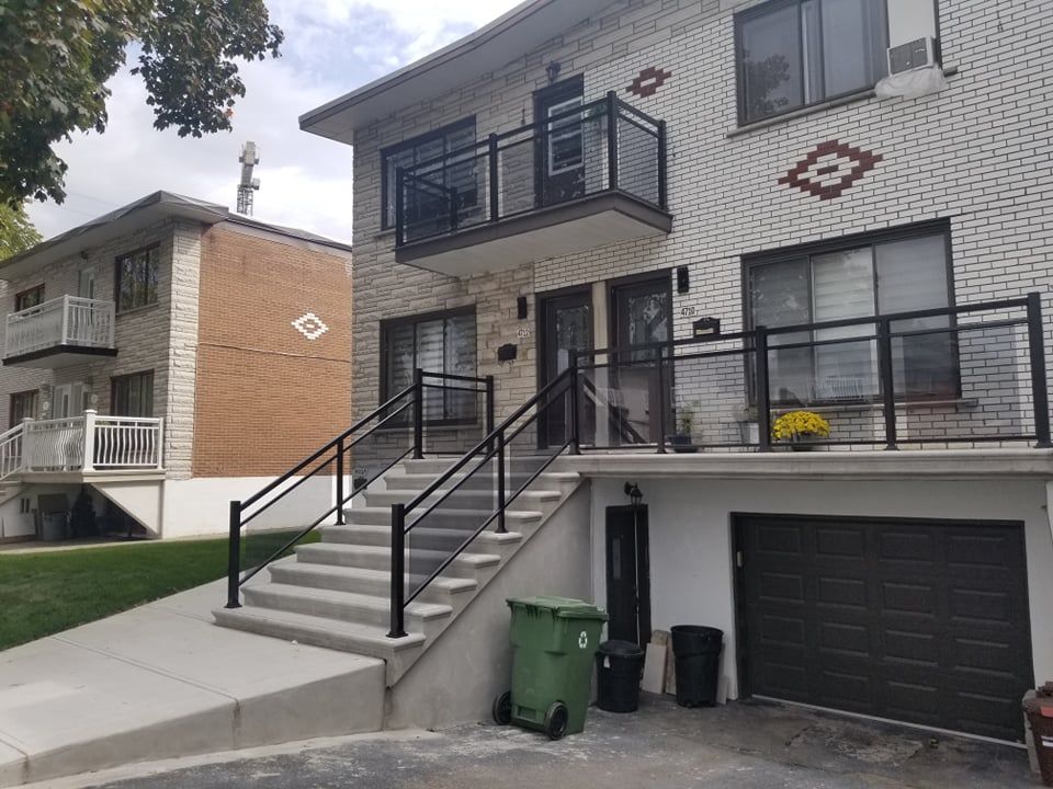 Une maison avec un balcon et des escaliers qui y mènent